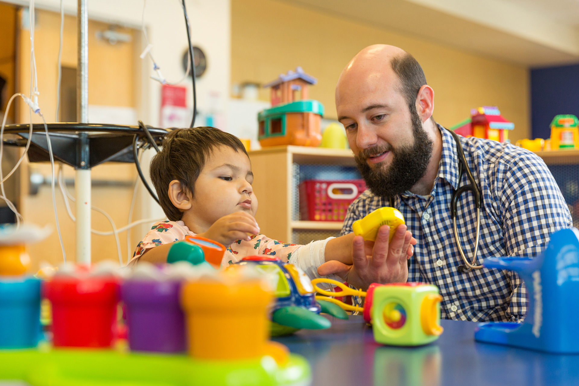 A young child plays with a child psychologist in a doctor's office